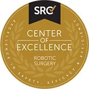 The image is a badge or emblem featuring the text  SCRC  in the upper left corner, with a logo that appears to be an acronym for a specific organization. Below the logo, there s a tagline that reads  Center of Excellence.  Further down, it states  ROBOTIC SURGERY,  followed by a laurel wreath symbolizing achievement or recognition. The badge has a circular shape with a gold border and a white background, giving it an official look.