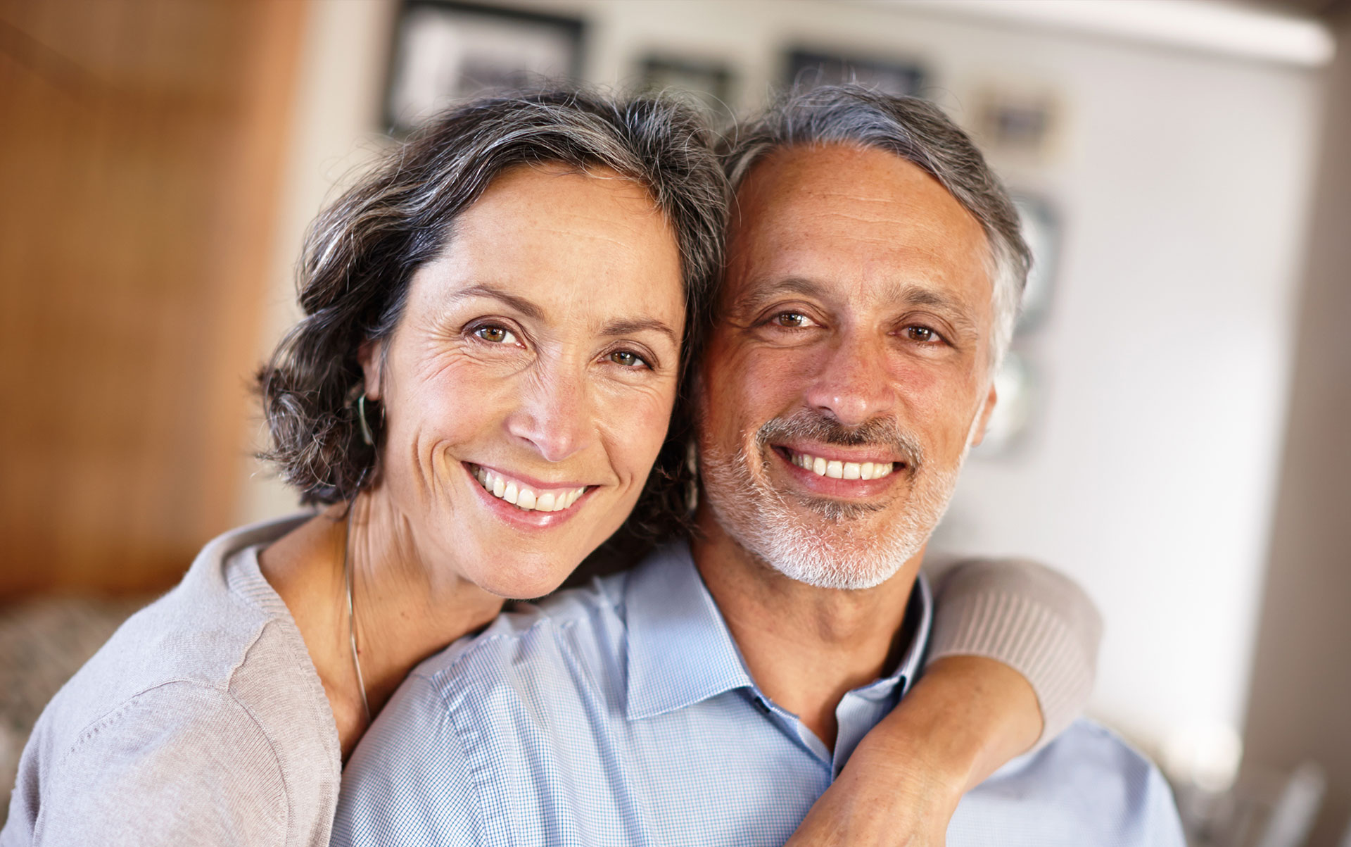 A man and a woman posing for a photo, smiling at the camera.